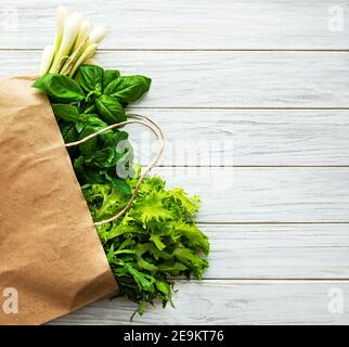 Frisches Grün in einer Papiertüte auf einem Holzhintergrund Stockfoto