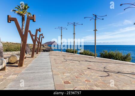 Kleiner platz mit Windskulpturen auf der Calle Los Rocas und Blick auf Montana roja, roter Berg, in Los Abrigos, Teneriffa, Kanarische Inseln, Spanien Stockfoto