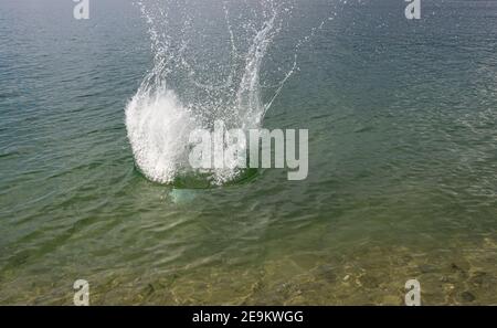 Spritzer, Wellen, Kreise, die von Steinen ins Meer geworfen, Tropfen von frischem, hellem Wasser, Rauschen, Splash. Wellen auf Meer abstraktes Texturmuster. Stockfoto