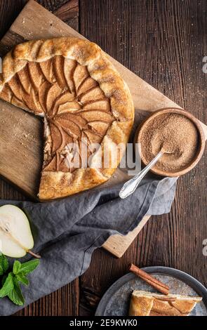 Juicy Birne Galette mit Frischkäse Füllung, bestreut mit Zimtzucker auf rustikalem Holzhintergrund Stockfoto