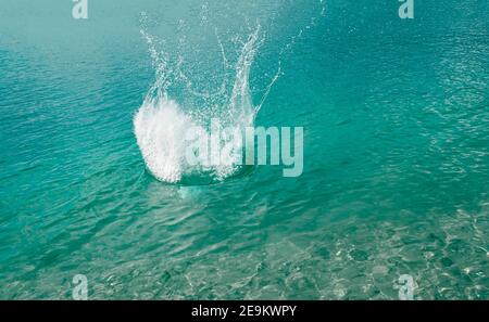 Spritzer, Wellen, Kreise, die von Steinen ins Meer geworfen, Tropfen von frischem, hellem Wasser, Rauschen, Splash. Wellen auf Meer abstraktes Texturmuster Stockfoto