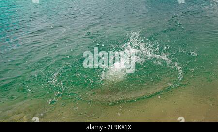 Spritzer, Wellen, Kreise, die von Steinen ins Meer geworfen, Tropfen von frischem, hellem Wasser, Rauschen, Splash. Wellen auf Meer abstraktes Texturmuster Stockfoto