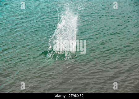 Spritzer, Wellen, Kreise, die von Steinen ins Meer geworfen, Tropfen von frischem, hellem Wasser, Rauschen, Splash. Wellen auf Meer abstraktes Texturmuster Stockfoto