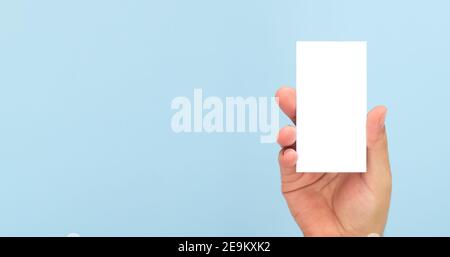 Person mit leerer Visitenkarte auf hellblauem Hintergrund. Banner mit Kopierbereich Stockfoto