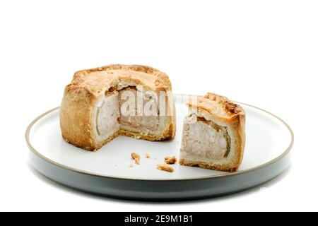Ein traditioneller, handgekräuselter Melton Mowbray Pork Pie. Ein traditionelles englisches Schweinefleisch mit einer gehackten Schweinefleischfüllung, gelierte Schweinefond in einem Krustengebäck Stockfoto