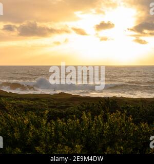Der Sonnenuntergang über dem Pazifischen Ozean vom Big Sur Strand Stockfoto