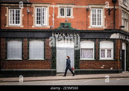 Eine Frau, die vorbeiging, war geschlossen und ging in die Kneipe Haus als Stadt geht in die Rezession und Geschäfte schließen unter Covid 19 Pandemiesperre Stockfoto