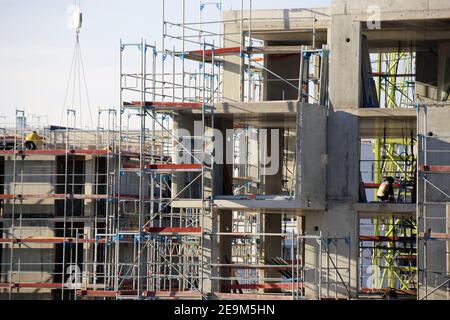 Große Baustelle in einem neu erschlossenen Wohngebiet. Mehrere Wohngebäude sind noch im Bau Stockfoto