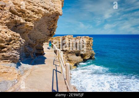 Blick auf den Weg, der entlang der Küstenfelsen von Sa Riera zu Pals Strand, mit einem touristischen Spaziergang läuft. Pals, Katalonien, Spanien Stockfoto