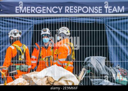 London, Großbritannien. Februar 2021, 5th. Das Notfallteam wartet - das Anti HS2 Extinction Rebellion Camp wird weiterhin von Gerichtsvollzieher (vom National Enforcement Team, NET, einer Tochtergesellschaft der High Court Enforcement Group) auf der Euston Station geräumt (um einen temporären Parkplatz zu schaffen). Alle oben genannten Demonstranten wurden geräumt und beginnen nun, die Tunnel zu graben. Kredit: Guy Bell/Alamy Live Nachrichten Stockfoto