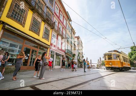 Porto, Portugal - 11. August 2020: Touristen, die Fotos von herannahenden Oldtimer-Tram machen Stockfoto