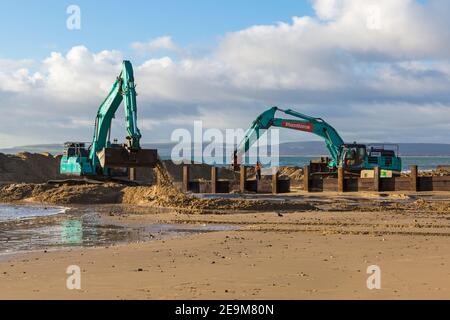 Schwere Maschinen arbeiten an Holz groyne Erneuerung Programm findet am Strand in Alum Chine, Bournemouth, Dorset UK im Februar Stockfoto