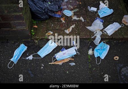 Weggeworfene Gesichtsmasken liegen auf einem Bürgersteig in Brighton Stockfoto