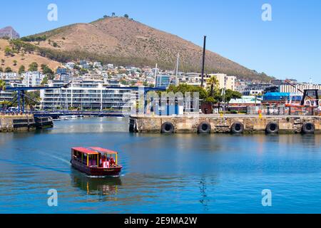 Waterfront - Kapstadt, Südafrika - 03-02-2021 atemberaubende Aussicht auf Red Penny Fähre schwimmend auf dem Wasser, Berg und Brücke überqueren. Stockfoto