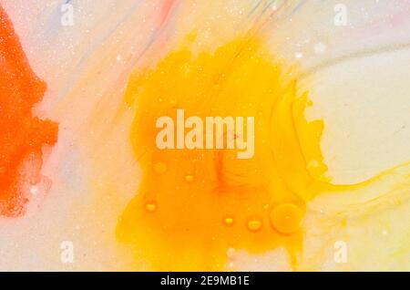 Flüssige helle Aquarellfarben mit Öl erzeugen flüssige Strukturen und Blasen in Rot, Orange, Gelb, Blau, Weiß und Rosa Stockfoto