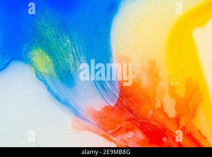 Flüssige helle Aquarellfarben mit Öl erzeugen flüssige Strukturen und Blasen in Rot, Orange, Gelb, Blau, Weiß und Rosa Stockfoto