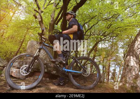 Mountainbiker macht eine Pause im Wald (Model veröffentlicht) Stockfoto