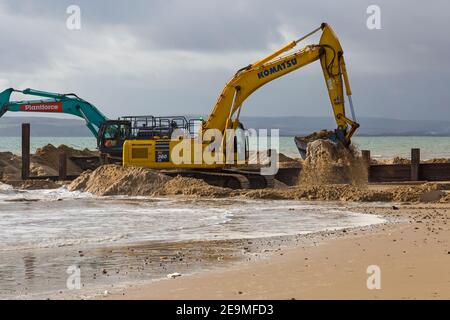 Schwere Maschinen arbeiten an Holz groyne Erneuerung Programm findet am Strand in Alum Chine Bournemouth, Dorset UK im Februar Stockfoto