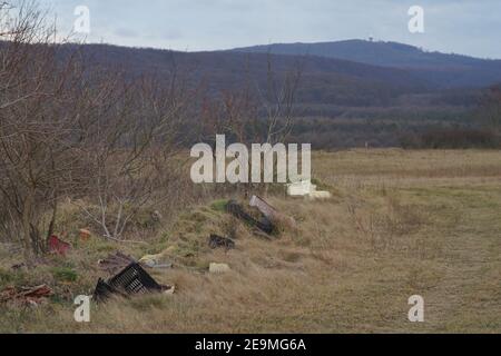 Bakonykoppany, Ungarn - 03. Febr. 2021: Eine illegale Mülldeponie am Fuße des Bakony-Gebirges in Ungarn(Kőris-hegy ist im Hintergrund sichtbar Stockfoto