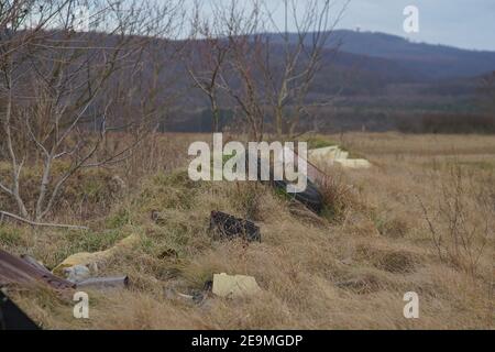 Bakonykoppany, Ungarn - 03. Febr. 2021: Eine illegale Mülldeponie am Fuße des Bakony-Gebirges in Ungarn(Kőris-hegy ist im Hintergrund sichtbar Stockfoto