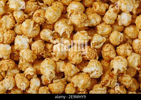 Popcorn in Karamell Glasur Nahaufnahme als Hintergrund. Köstliches Lob für das Ansehen von Filmen, Serien, Cartoon. Nahaufnahme Stockfoto