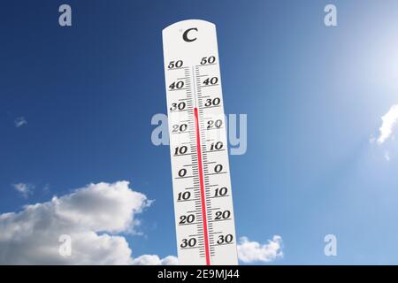 Symbolbild: Thermometer vor blauem Himmel zeigt warme Temperaturen Stockfoto