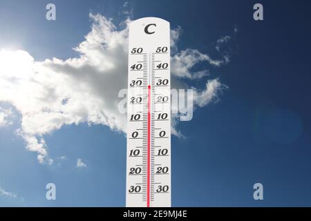 Symbolbild: Thermometer vor blauem Himmel zeigt warme Temperaturen Stockfoto