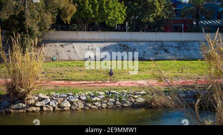 Fuengirola, Malaga, Spanien. Januar 2021. Ein älterer Mann, der an einem sonnigen Wintermorgen im Flusspark von Fuengirola Fahrrad fährt. Stockfoto