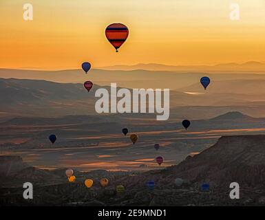 Heißluftballons fliegen bei Sonnenaufgang über Kappadokien, Provinz Nevşehir in Zentralanatolien, Türkei Stockfoto