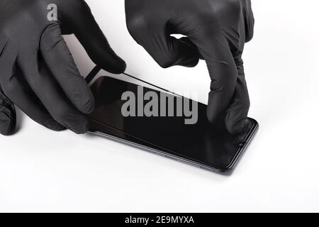 Ein Mann ist ein Schutzglas auf dem Bildschirm eines Smartphones. Stockfoto