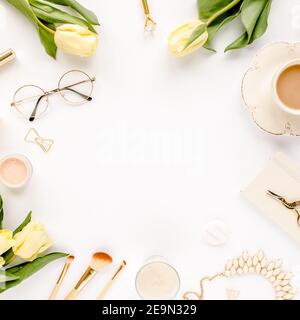 Weiblicher Arbeitsplatz mit gelben Tulpenblüten, Damenmode goldene Accessoires, Tagebuch, Gläser auf weißem Hintergrund. Flach liegend. Feminine Draufsicht. Stockfoto