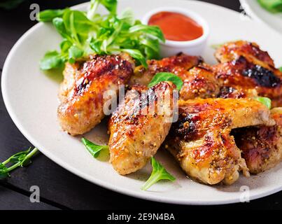 Gegrillte Hähnchenflügel. Gebackene Hähnchenflügel auf Holztisch. Stockfoto