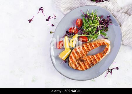 Lachs. Lachs Fisch Steak gegrillt und Tomaten-Salat mit Microgreens. Gesunde Ernährung. Draufsicht, Overhead, Kopierbereich. Stockfoto