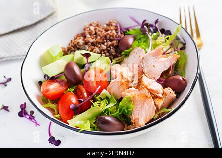 Lachssalat. Frischer Salat mit gegrilltem Lachs, Avocado, Kirschtomaten, Salat, Quinoa, Oliven- und Mikrogemüse. Hausgemachtes Essen. Konzept gesunde Mahlzeit Stockfoto