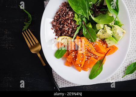 Vegane Mahlzeiten, Mittagessen. Buddha-Schale mit Quinoa, gebratenem Kürbis, Avocado und grünen Kräutern. Vegetarische, gesunde Ernährung Konzept. Draufsicht, Copy SPA Stockfoto