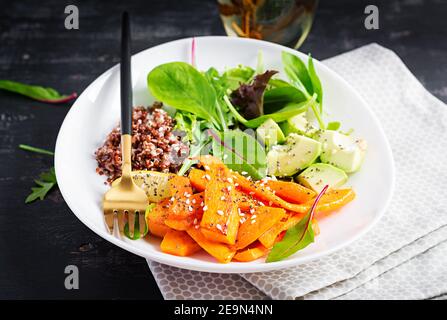 Vegane Mahlzeiten, Mittagessen. Buddha-Schale mit Quinoa, gebratenem Kürbis, Avocado und grünen Kräutern. Vegetarische, gesunde Ernährung Konzept. Stockfoto