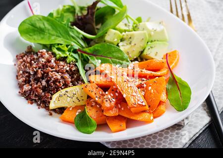 Vegane Mahlzeiten, Mittagessen. Buddha-Schale mit Quinoa, gebratenem Kürbis, Avocado und grünen Kräutern. Vegetarische, gesunde Ernährung Konzept. Stockfoto