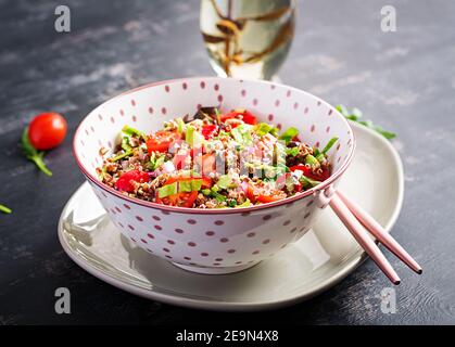 Tabbouleh mit Quinoa. Tabbouleh Salad: Traditionelle Gerichte aus dem Nahen Osten oder der arabischen Küche. Vegetarischer Salat mit Quinoa, Tomaten, Avocado, grünen Kräutern und Stockfoto