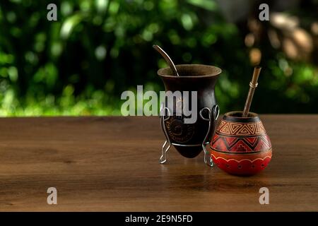 Zwei traditionelle Kumpels aus Kalabash über einem Holztisch im Freien. Speicherplatz kopieren. Kultur südamerikas. Stockfoto