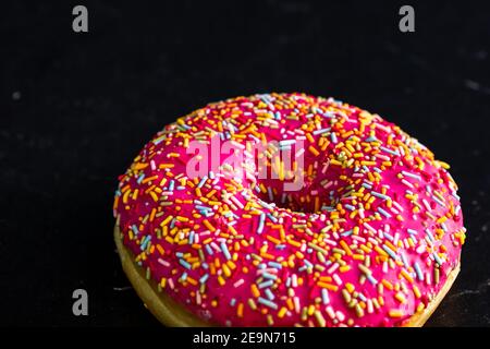 Rosa glasierte Donut mit Streuseln isoliert. Nahaufnahme von bunten Donut. Stockfoto