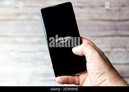 Ein Mobiltelefon oder Mobiltelefon, das/das gehalten wird, zeigt das an Amazon Prime Video-App auf dem Bildschirm geöffnet Stockfoto