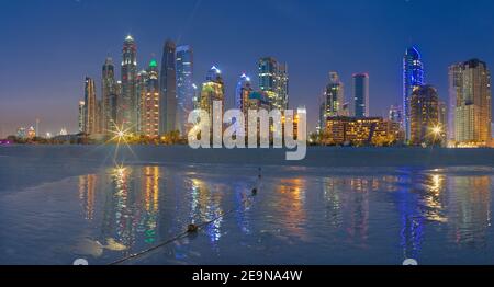 DUBAI, Vereinigte Arabische Emirate - 28. März 2017: Der Abend Skyline von Marina erhebt sich vom Strand entfernt. Stockfoto