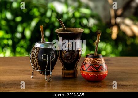 Drei traditionelle Kumpels aus Kalabash über einem Holztisch im Freien. Kultur südamerikas. Stockfoto