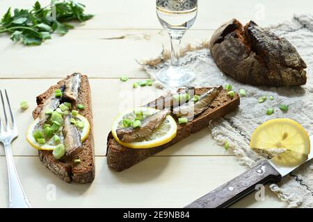 Sandwich mit Sprossen. Sprotte in Öl. Auf einem hölzernen Hintergrund. Stockfoto