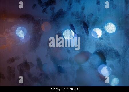 Blaue Nacht nassen Fensterfläche Vith mehrere Handflächen Drucke auf sie, abstrakter Hintergrund Stockfoto