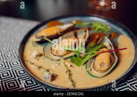 Großer Teller mit Muscheln in Tomatensauce mit Knoblauch, Petersilie und Zitrone gekocht. Freier Speicherplatz für Ihren Text Stockfoto