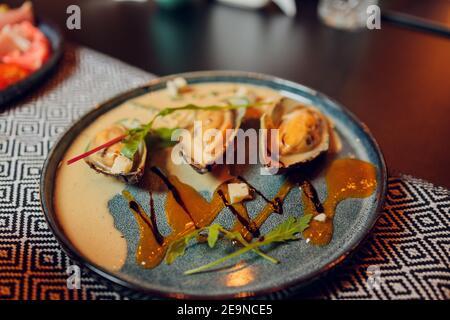 Großer Teller mit Muscheln in Tomatensauce mit Knoblauch, Petersilie und Zitrone gekocht. Freier Speicherplatz für Ihren Text Stockfoto