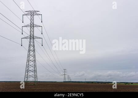 Hochspannungs-400 kV-Freileitung auf großen Pylonen, verwendet für große Entfernungen, sehr hohe Kraftübertragung. Wolkiger Himmel und Kopierbereich Stockfoto