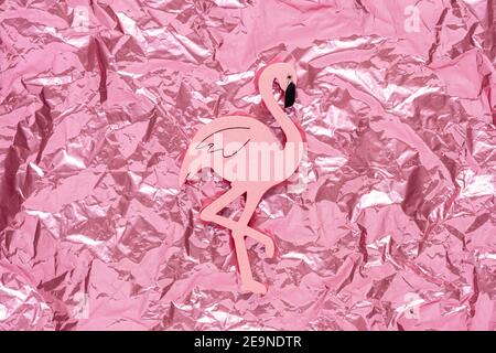 Pink Flamingo auf rosa gekrümmten Folie Hintergrund. Minimales Urlaubskonzept. Stockfoto