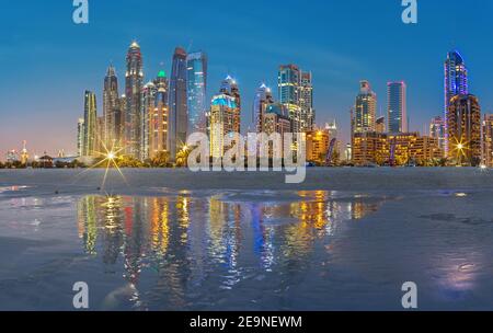 DUBAI, Vereinigte Arabische Emirate - 28. März 2017: Der Abend Skyline von Marina erhebt sich vom Strand entfernt. Stockfoto